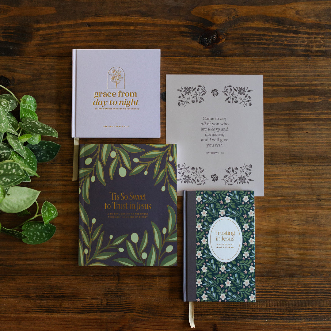 The Lent Bundle laying on a brown wooden table next to greenery