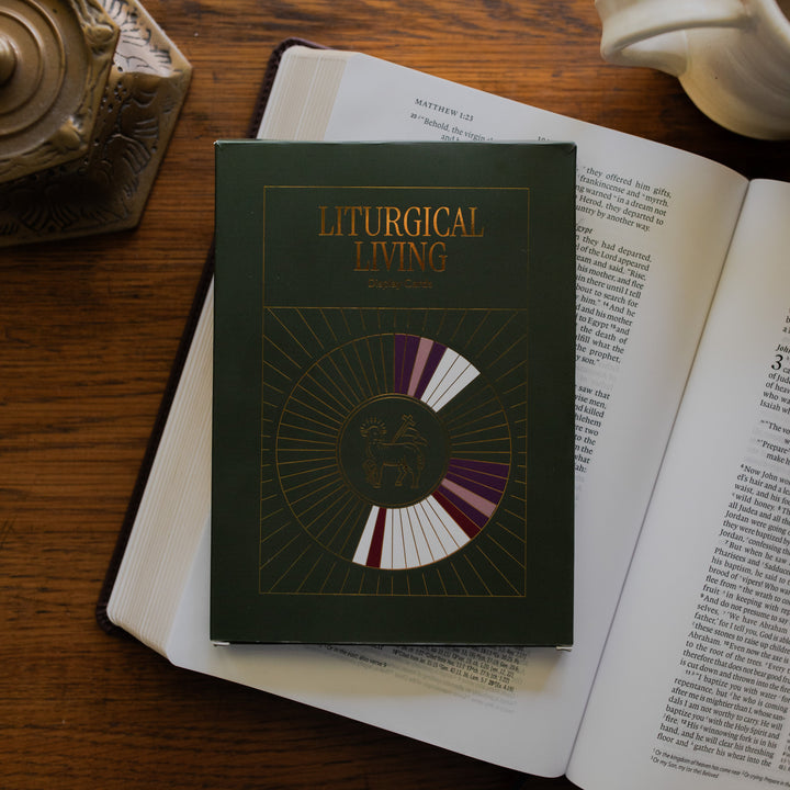 Liturgical Living Display Cards cover on an open bible on a wooden table