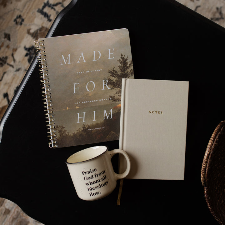 Notebook titled 'Made for Him', another notebook titled 'Notes', and a mug on a dark surface.
