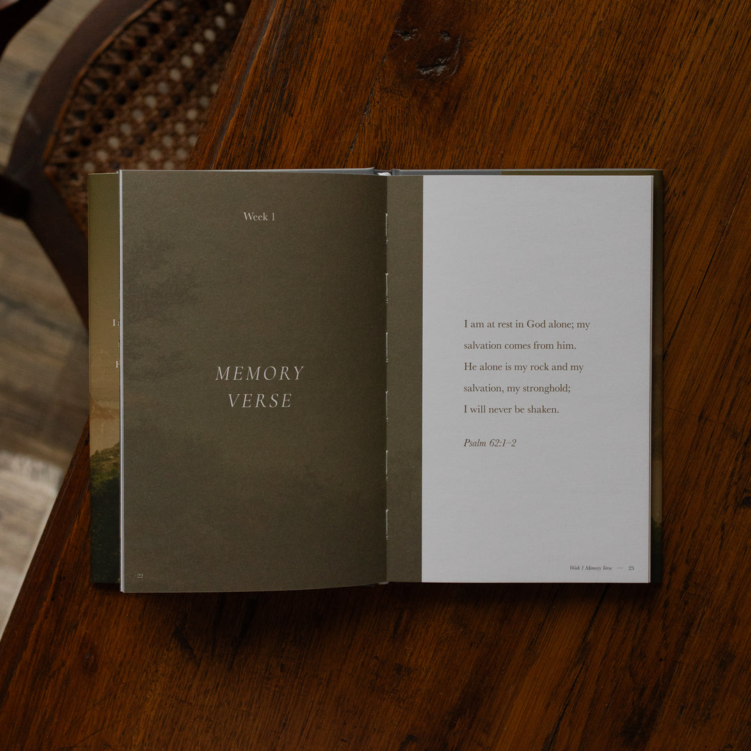 Made for Him book opened to the Week 1 Memory Verse page on a wooden table near a chair