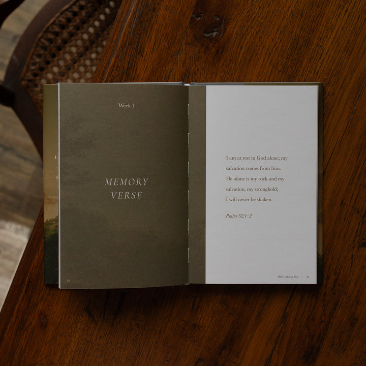 Made for Him book opened to the Week 1 Memory Verse page on a wooden table near a chair