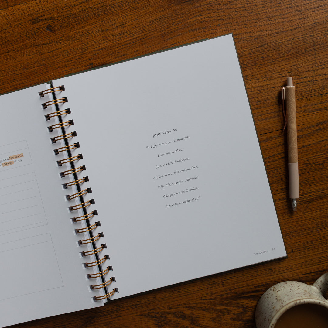 Mark It Up Journal opened to the verse map page of john close up next to a pen