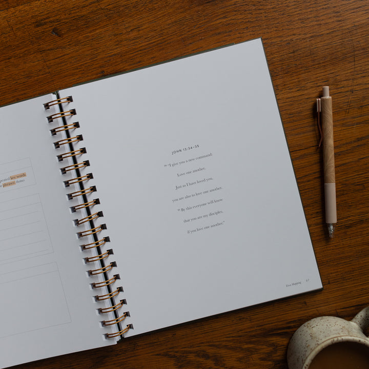 Mark It Up Journal opened to the verse map page of john close up next to a pen