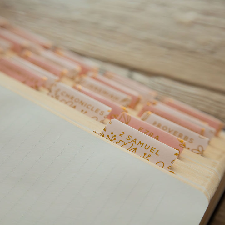 Close-up of a stack of books with visible titles on a wooden surface