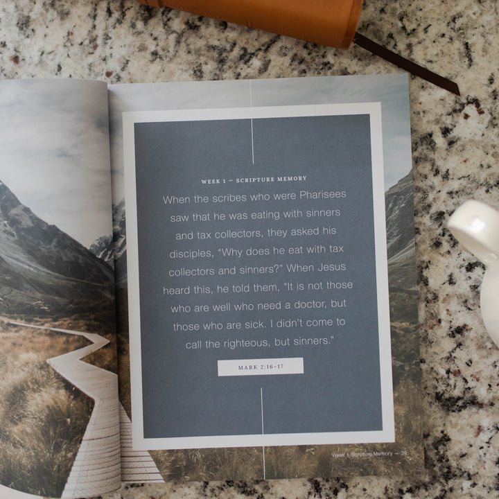 Mens Follow Me Matte study opened to the week 1 scripture memory page