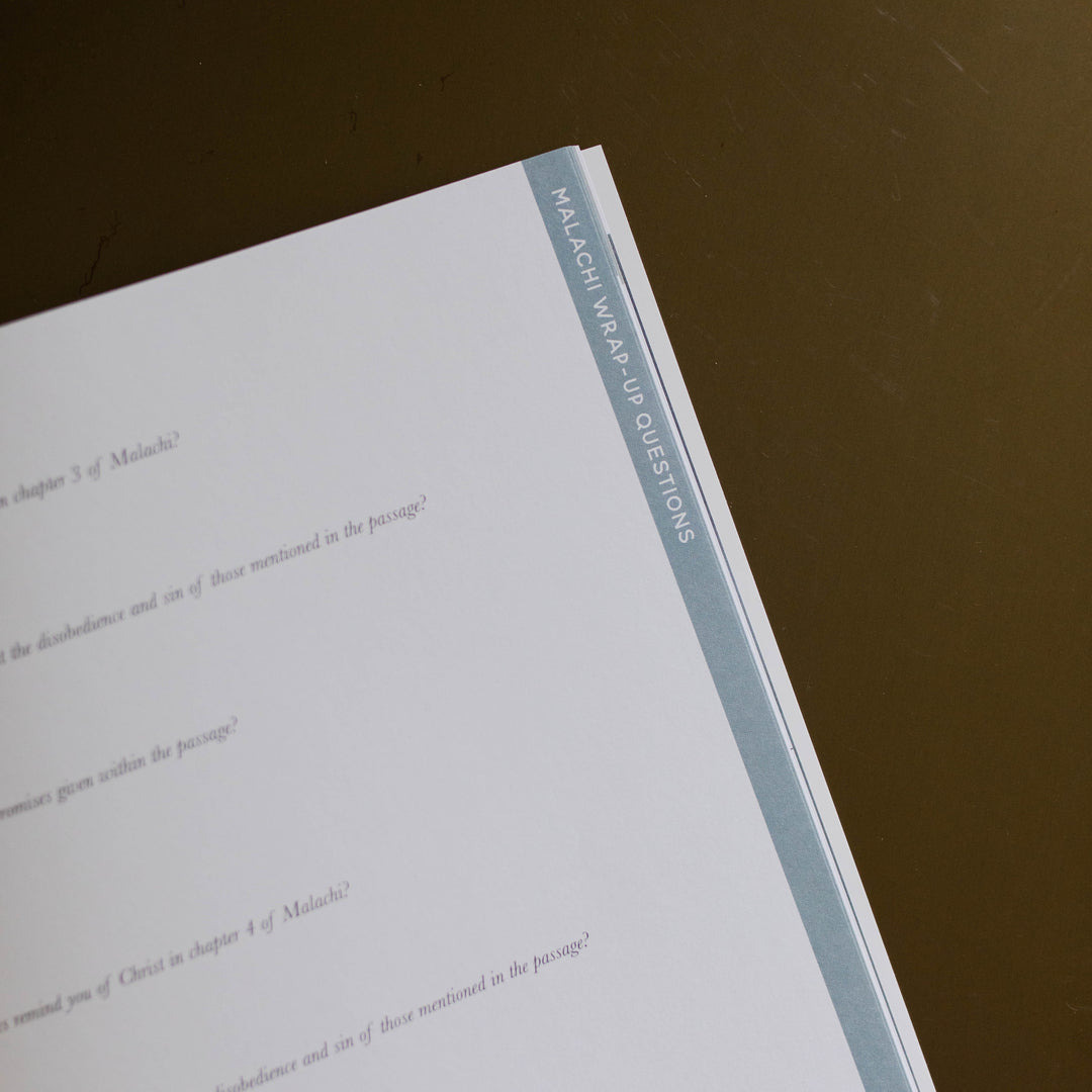 Mens Malachi Waiting for Hope Bible Study opened to Malachi Wrap-Up Questions close up of corner page sitting on a gold colored table
