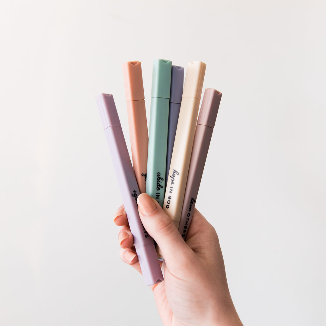 Muted Pastel Highlighters are being held up by a hand showcasing their dual tips.