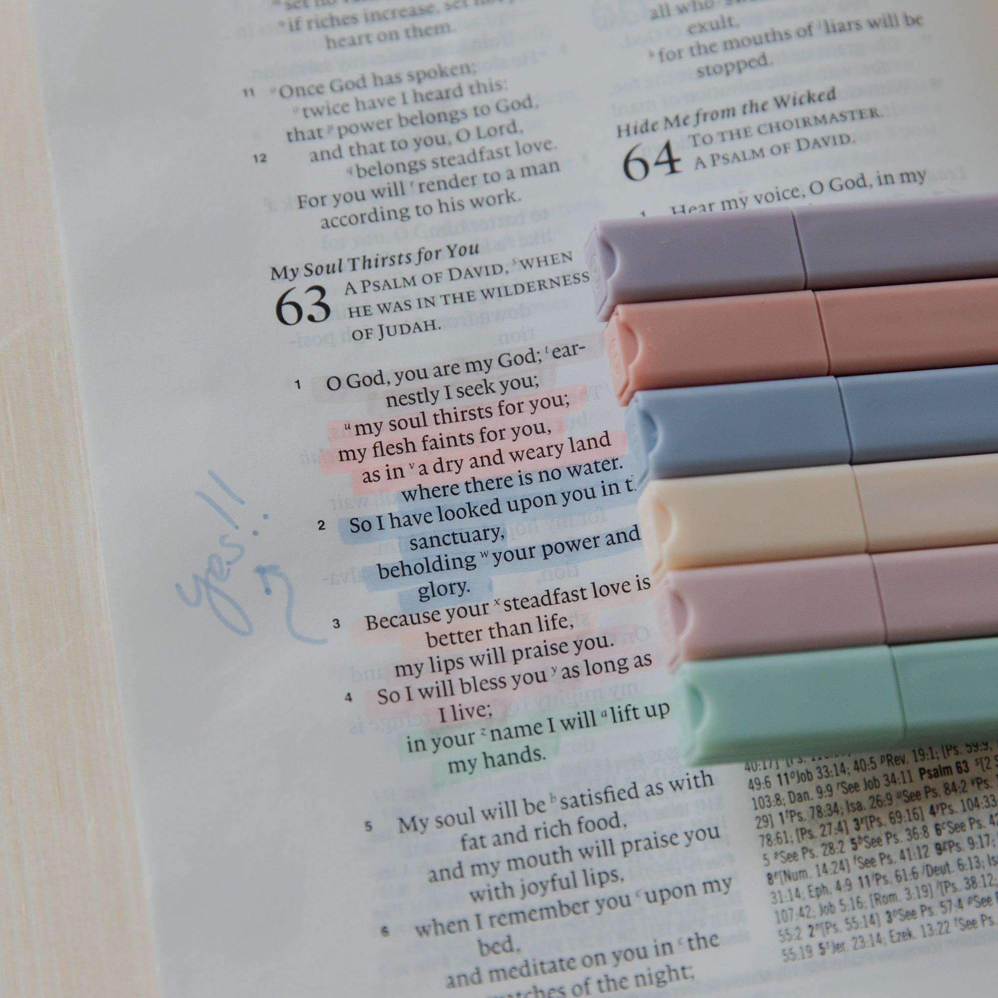 Open book with colorful highlighters on a white background