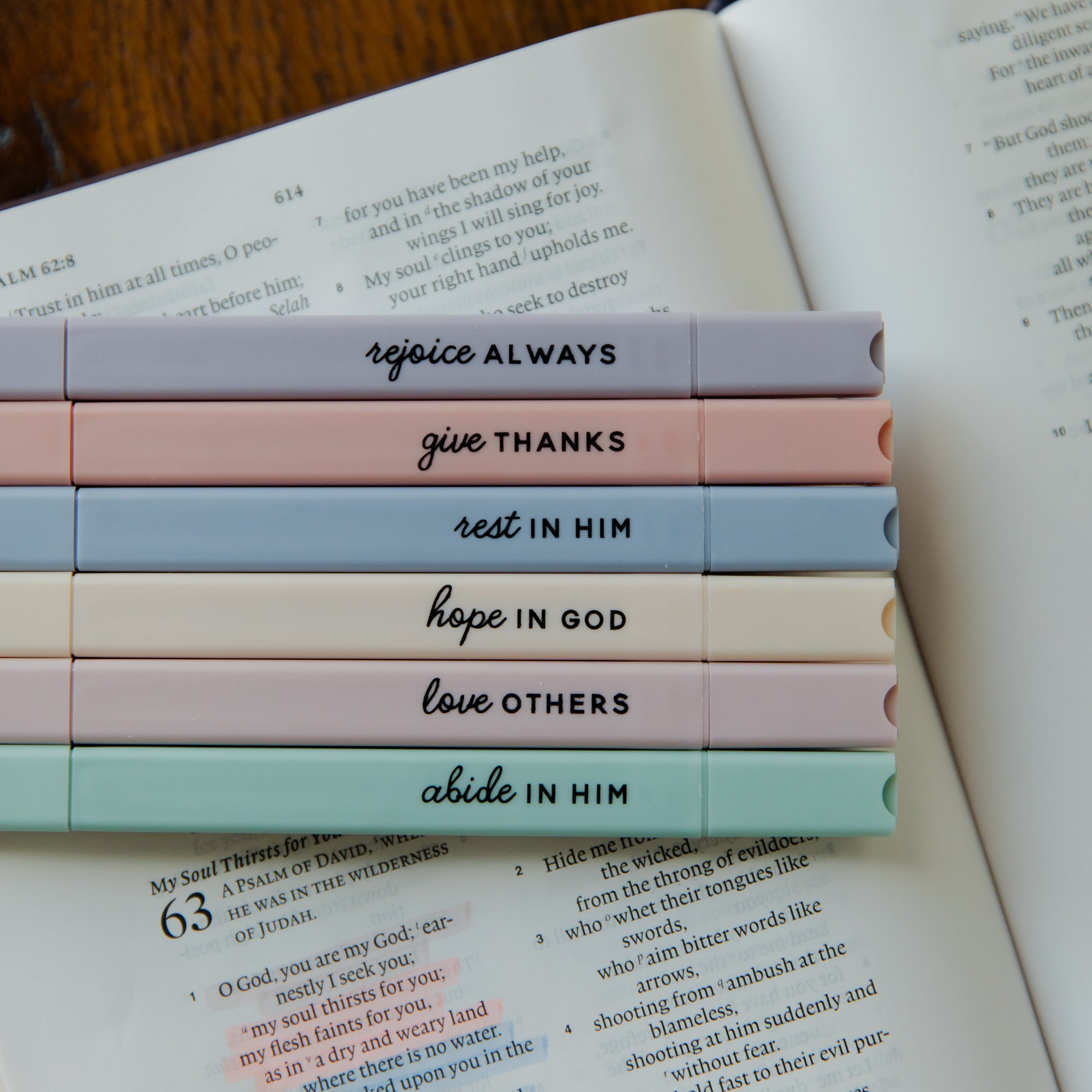 Stack of colorful pens with motivational phrases on a book