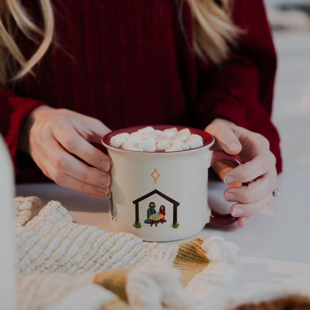 Woman holding Christmas Nativity Mug showing manger with star