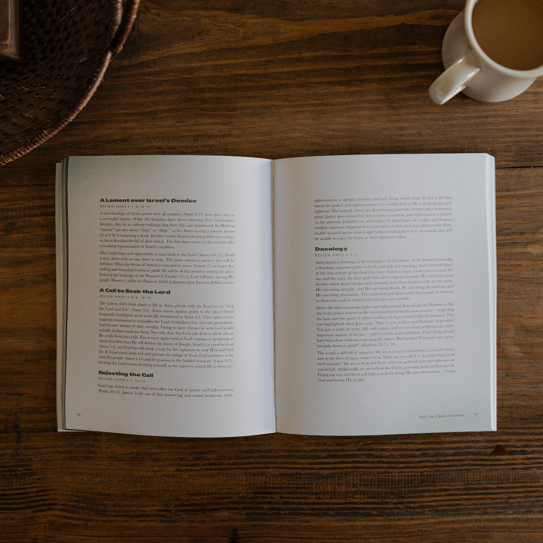 Never too far gone men's study opened to a doxology page next to a coffee cup on a wooden table