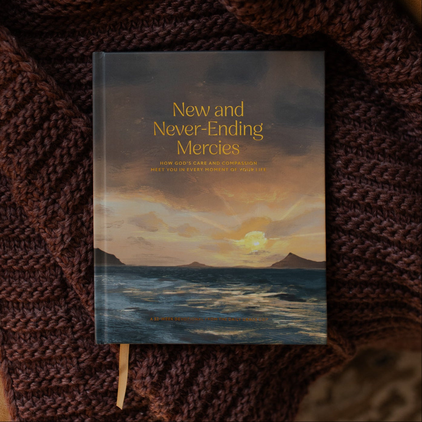 New and Never Ending Mercies on a brown knitted blanket on a leather couch