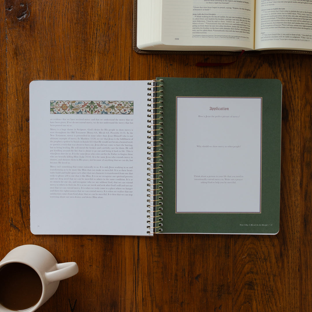 Open notebook with pages turned, a cup of coffee on a wooden surface
