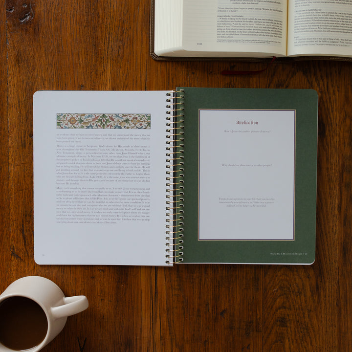 Open notebook with pages turned, a cup of coffee on a wooden surface