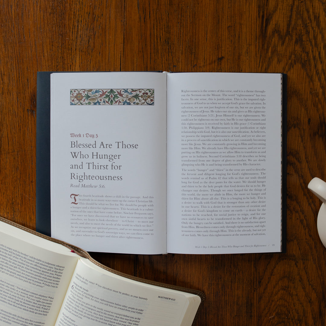 Open book on a wooden surface with text and decorative elements.