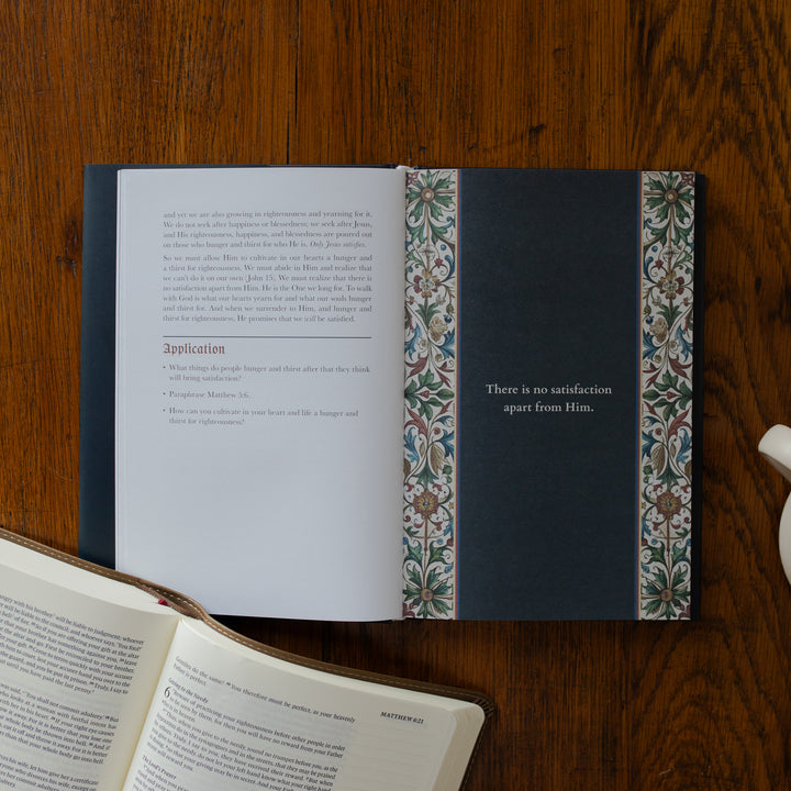 Open book with decorative binding on a wooden surface
