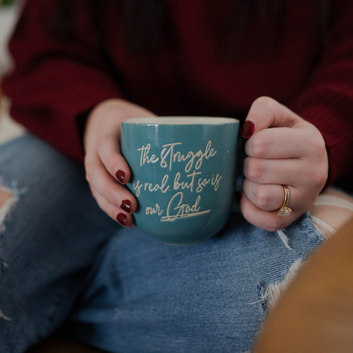 Woman holding Our God is Real ceramic Christian mug