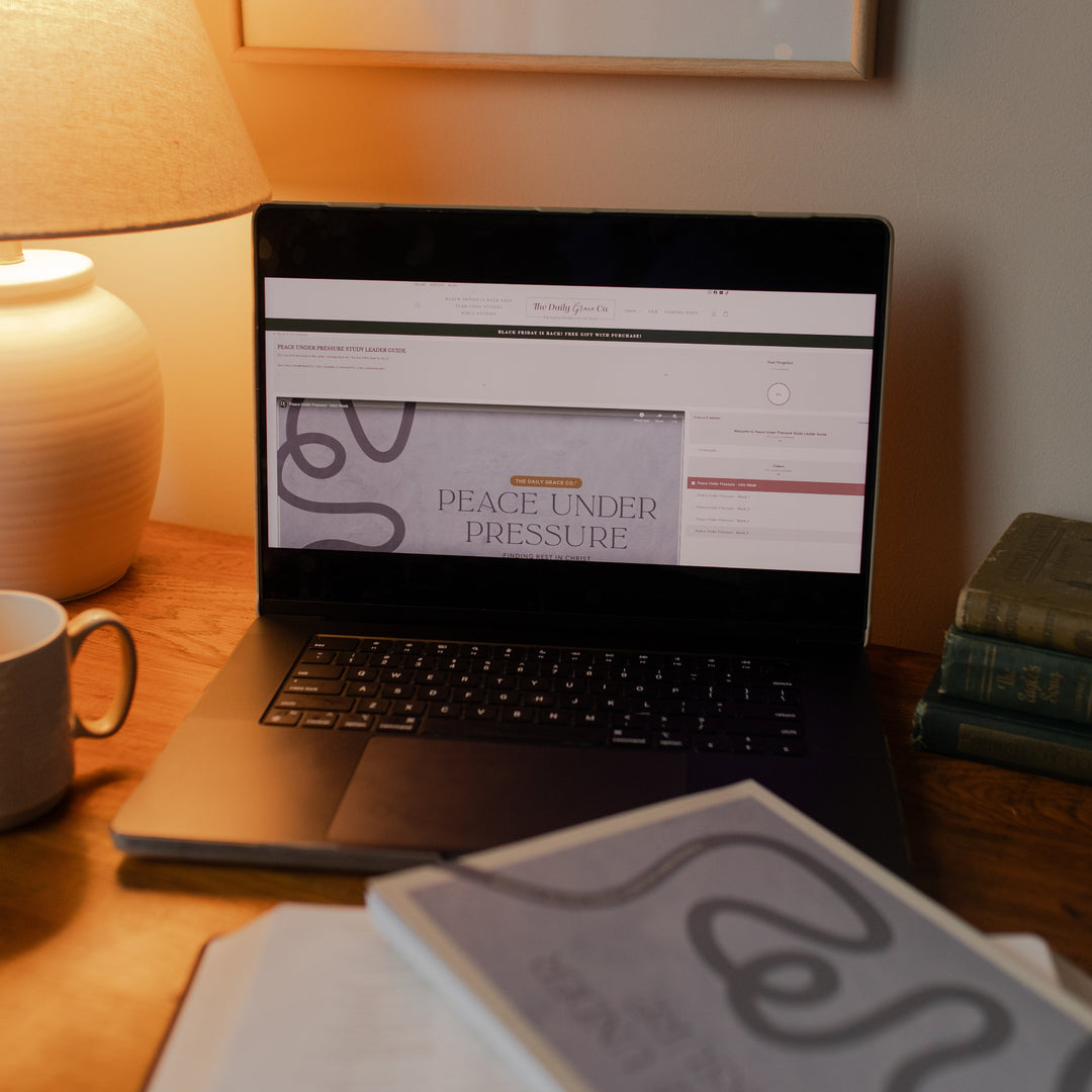 Peace under pressure loaded on a laptop with various books and studies nearby on a wooden desk