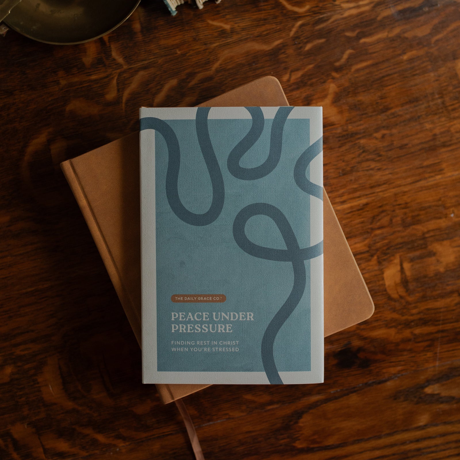 Peace Under Pressure Mens Cover on a journal on a wooden table