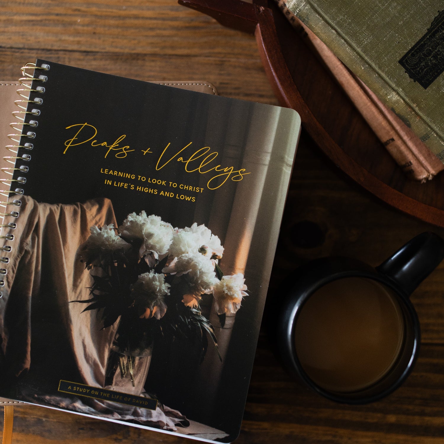 Peaks and Valleys Spiral Study up close next to a dark brown wooden tray with a black coffee cup next to it on a brown wooden table