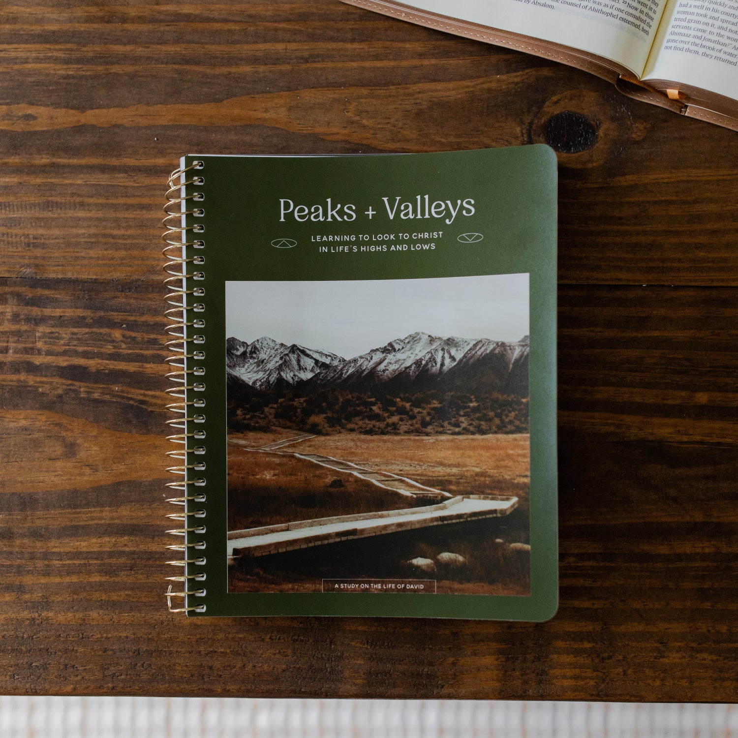 Peaks and Valleys Mens Spiral Study Cover on a brown wooden table next to an open book