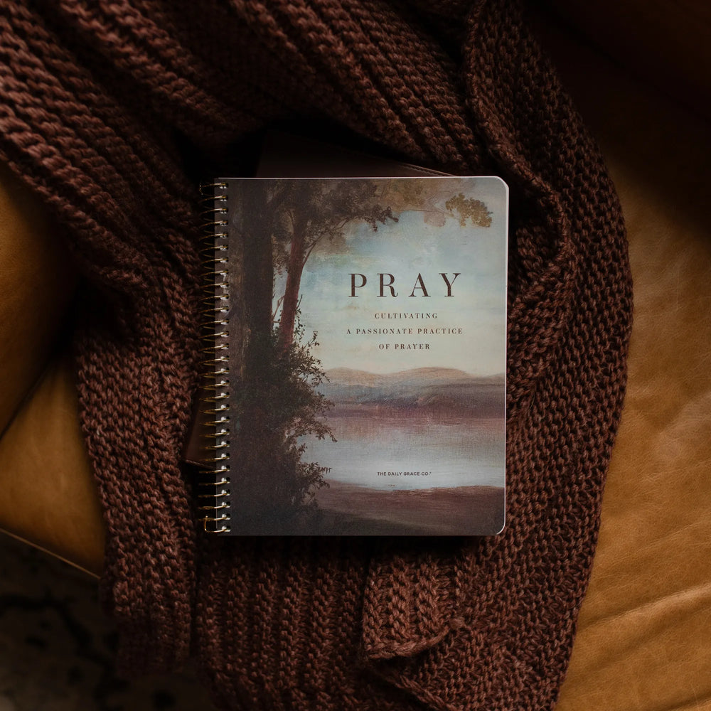The Pray Spiral Study cover on a closed bible on a woven blanket