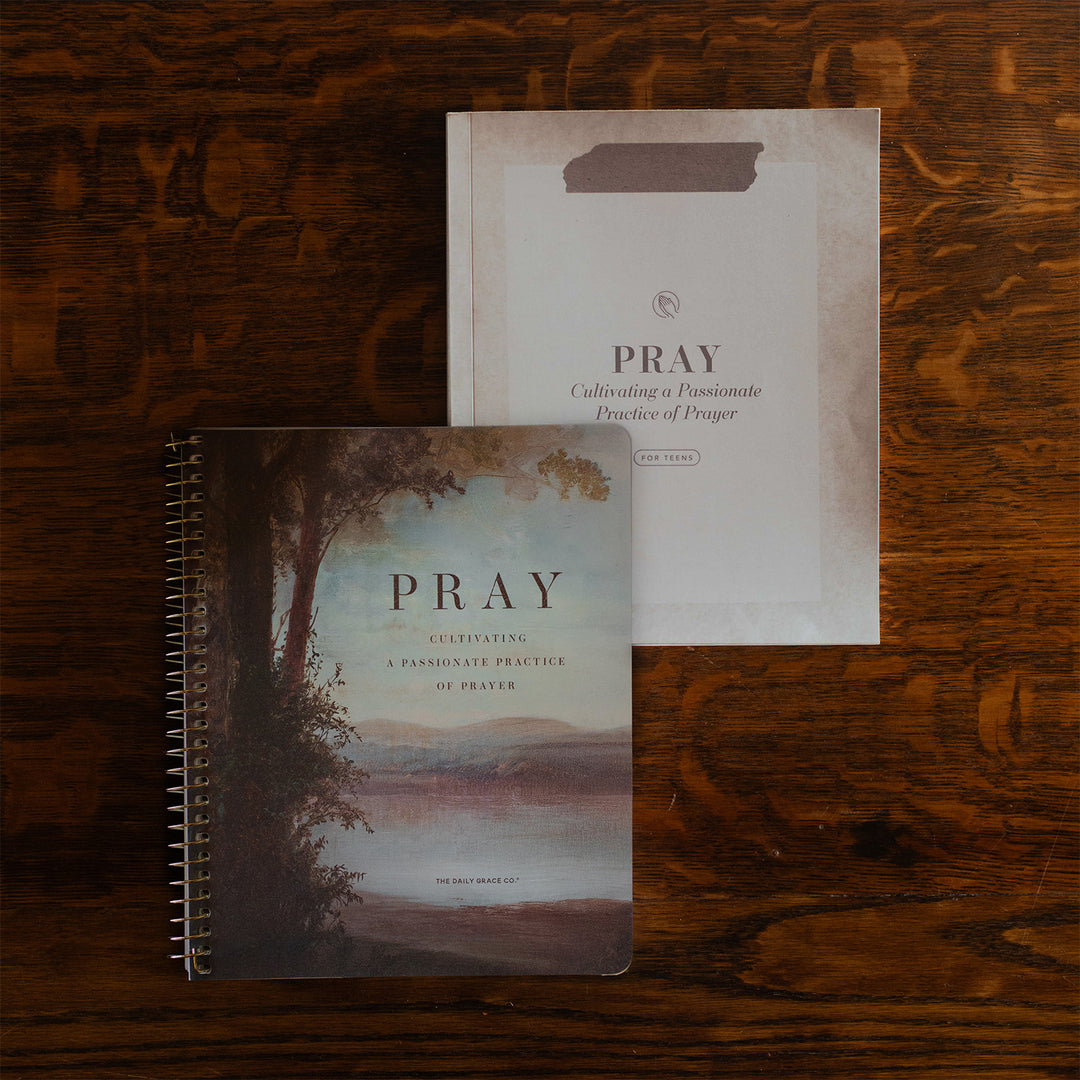 The Pray Women's study and the Pray Teens study cover on a wooden table