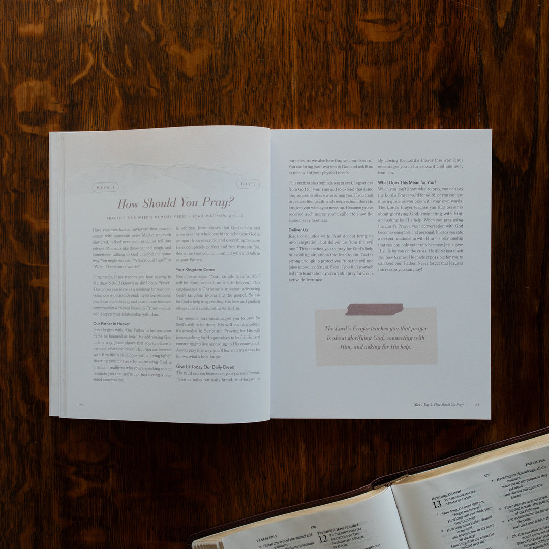 The Pray Study opened to the How should you pray page on a wooden table near an open bible