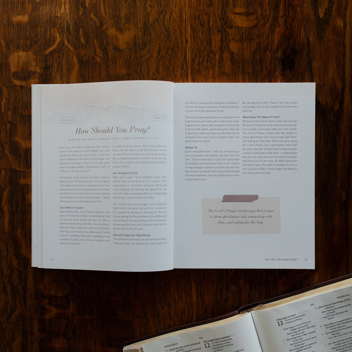 The Pray Study opened to the How should you pray page on a wooden table near an open bible