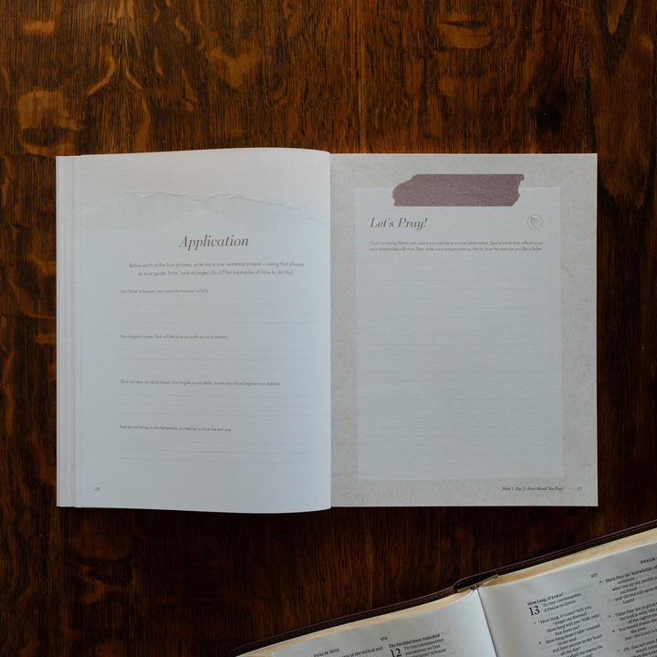 The Pray Study opened to the applications page on a wooden table near an open bible