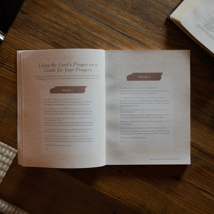 The Pray study opened to the prayers page on a wooden table near an open bible