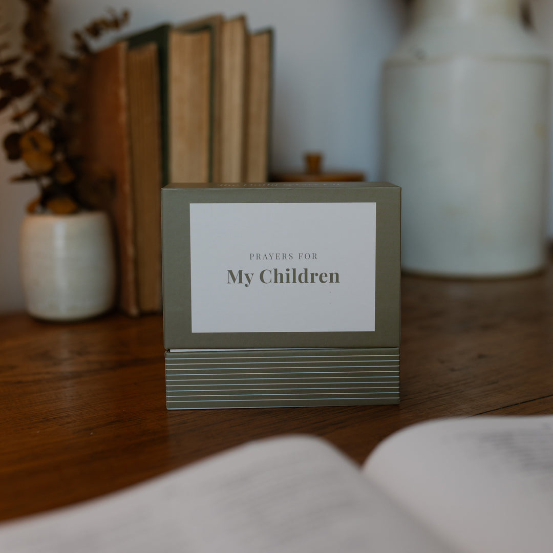 A Box full of verse cards for prayers for children on a wooden desk