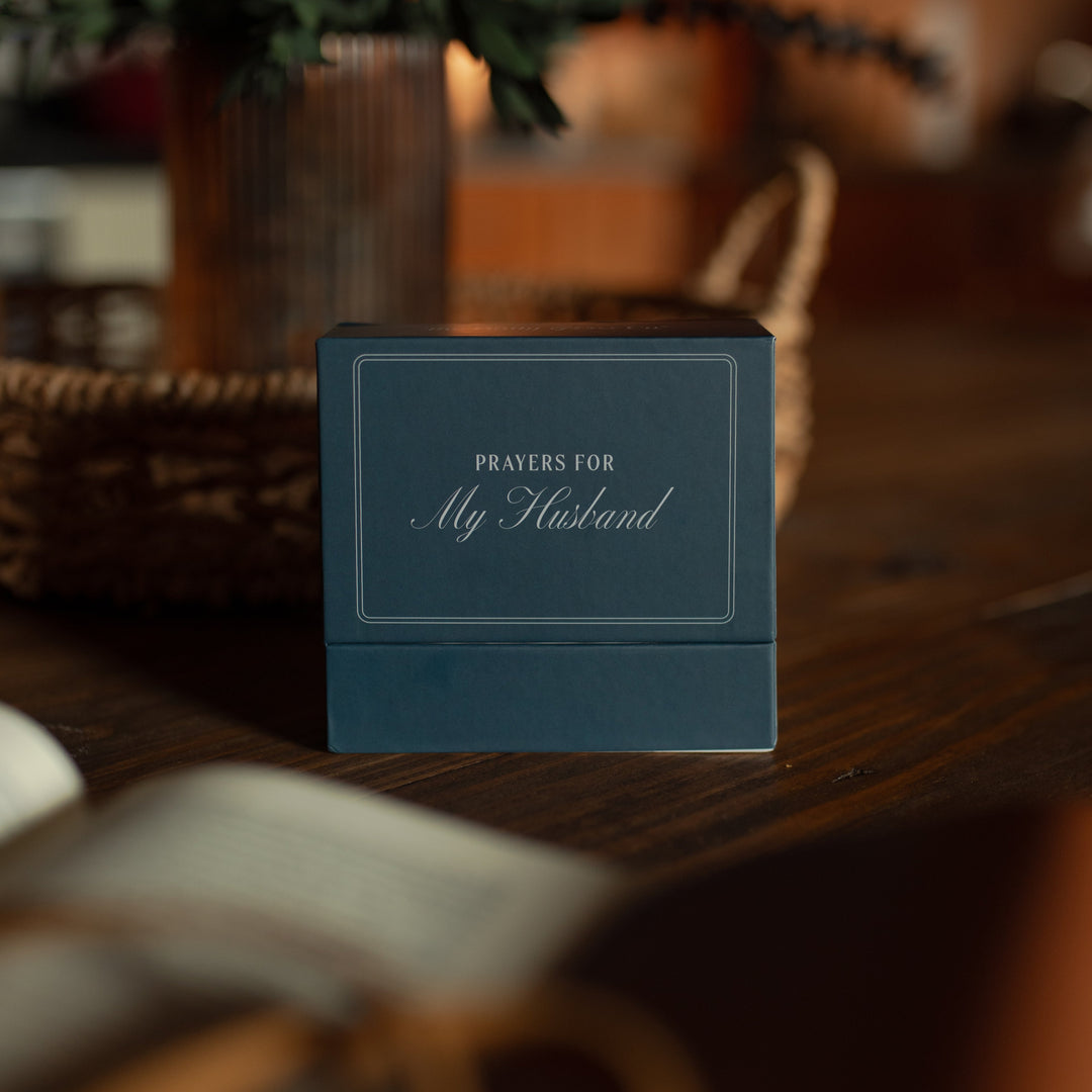 Blue box with 'Prayers for My Husband' text on a wooden surface near a potted plant