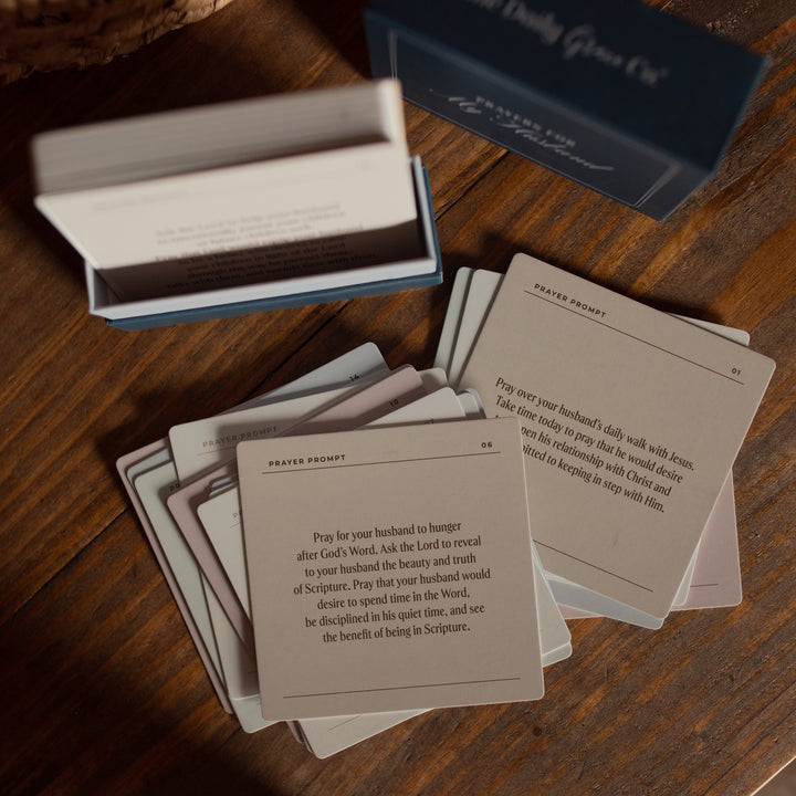 Set of prayer cards with a blue box labeled 'The Daily Prayer' on a wooden surface.