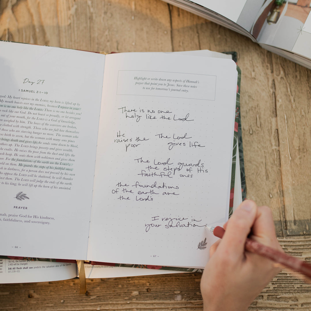 Close up of daily entry and woman writing in Advent prayer journal