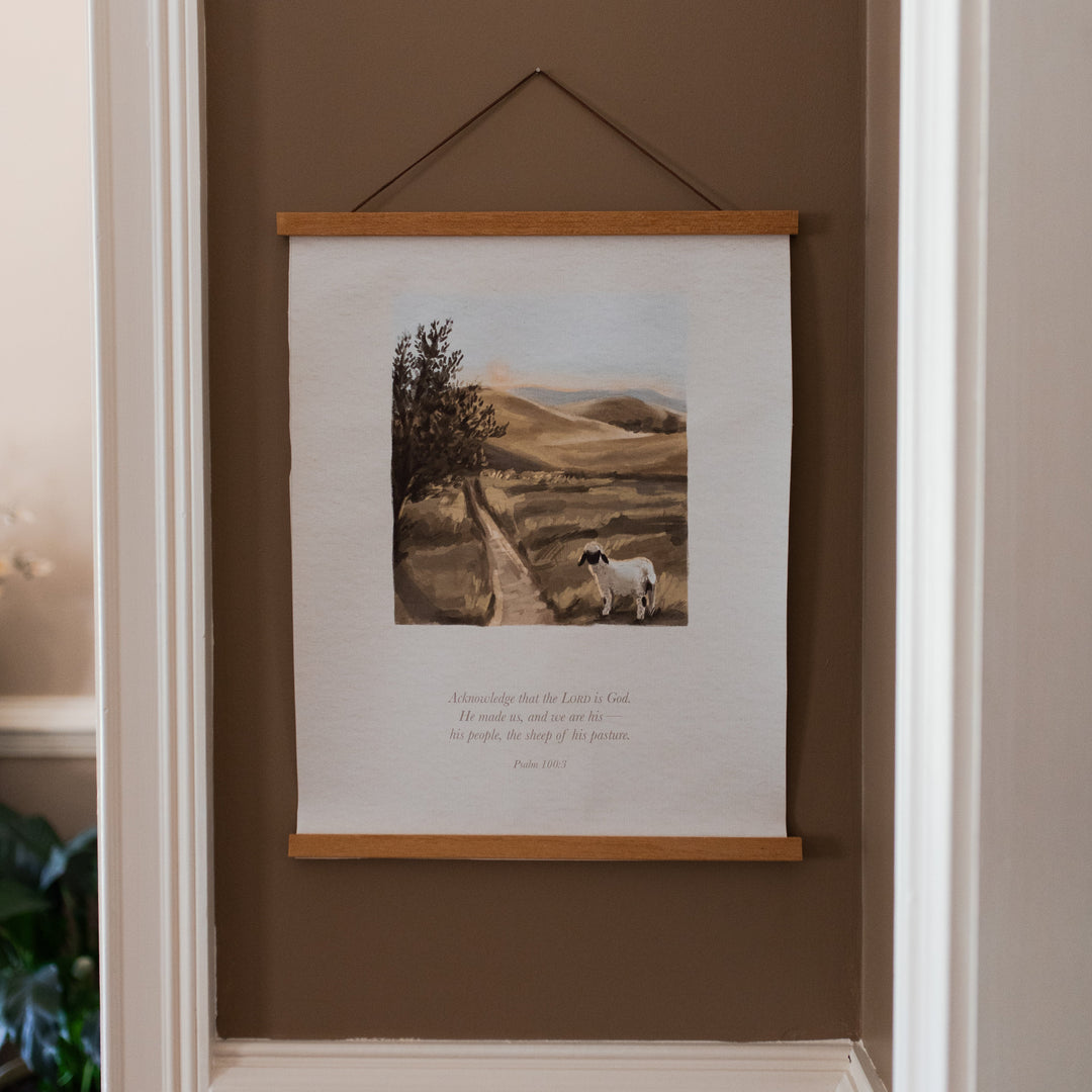 Sheep of his Pasture Canvas hanging on a brown wall with white trim