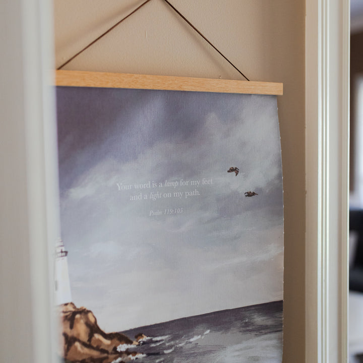 Psalm 119 Lighthouse Painting Print at an angle on a light colored wall with white trim