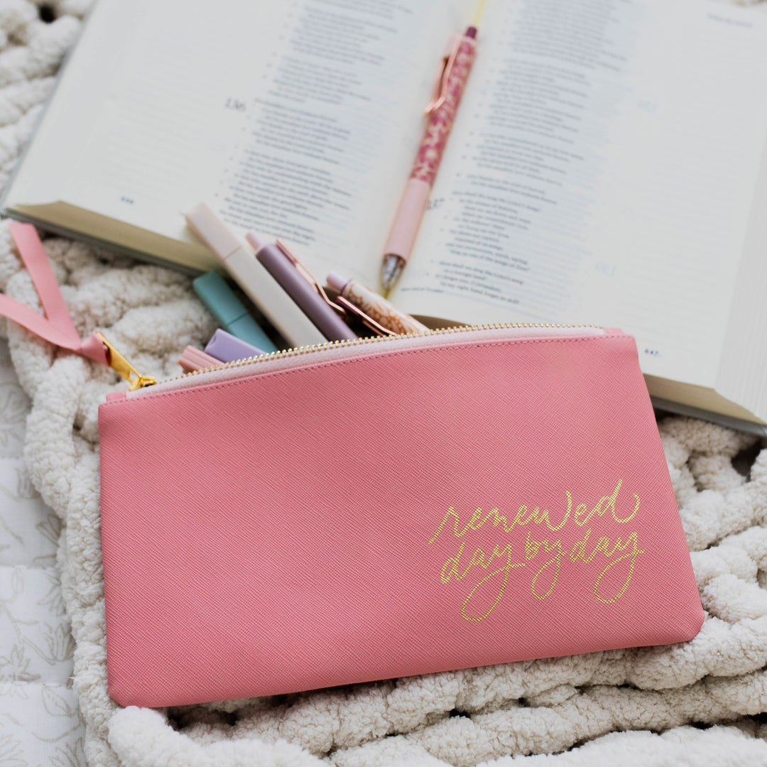 Renewed Day by Day Pencil Pouch - Blossom Pink full of highlighters and pencils near a Bible with a pen. 