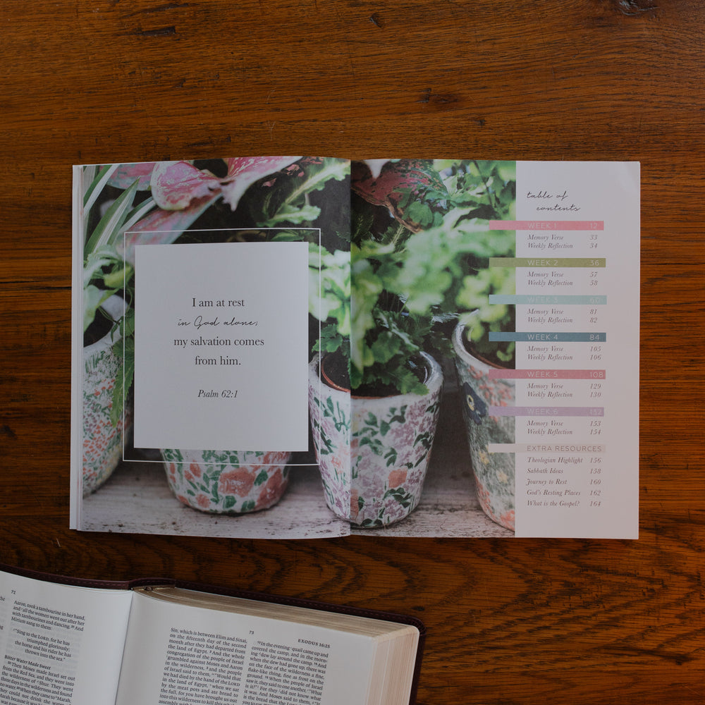 The Rest Matte study opened to the table of contents on a wooden desk near an open bible