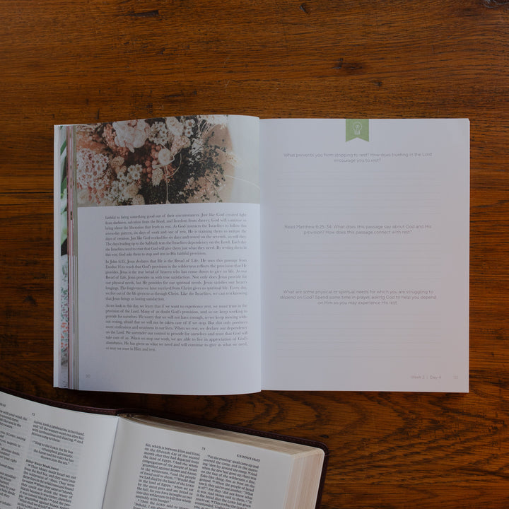 The Rest Matte study opened to the questions and applications page on a wooden desk near an open bible