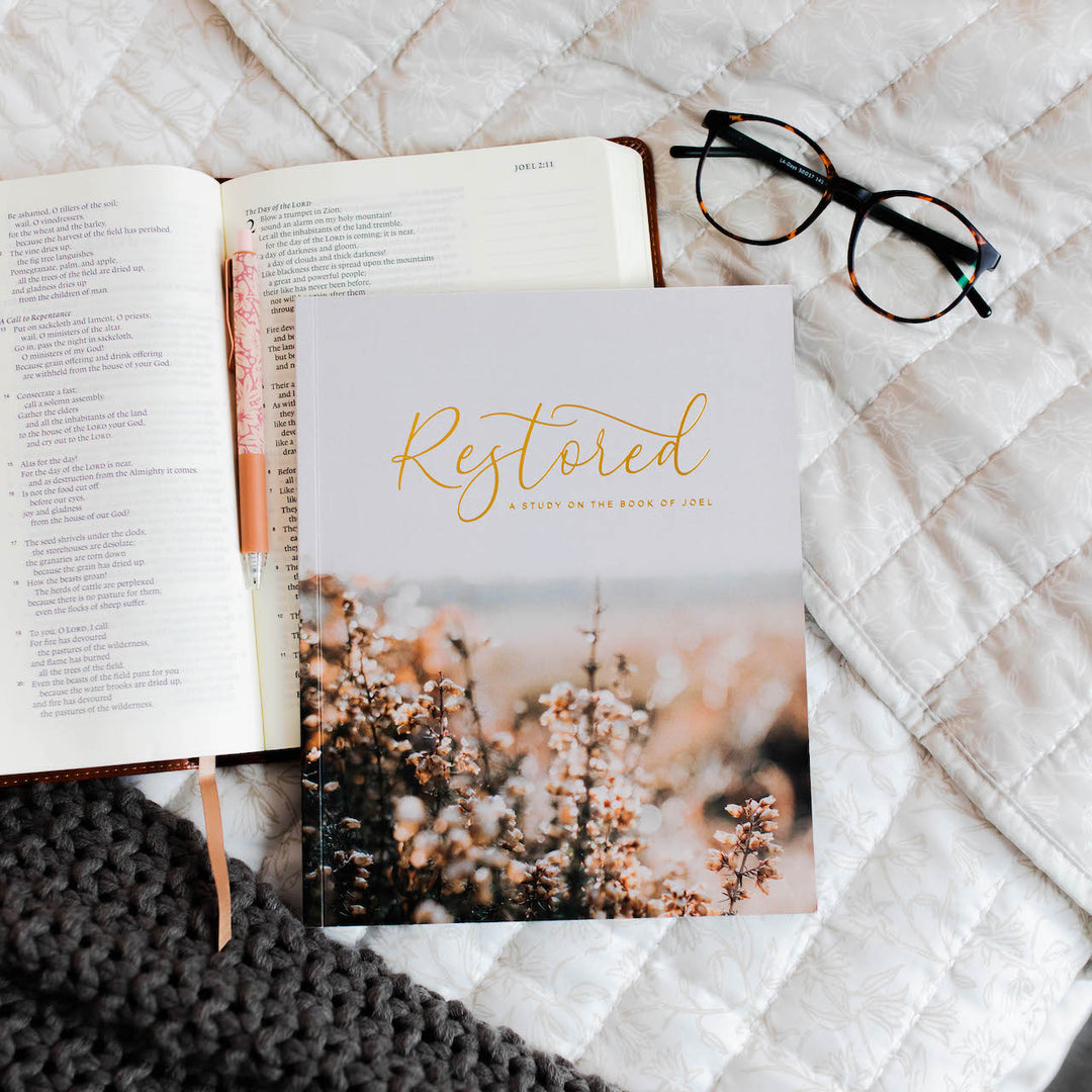 Bible study on the book of Joel. Bible study is sitting on top of a Bible next to a pair of glasses. 