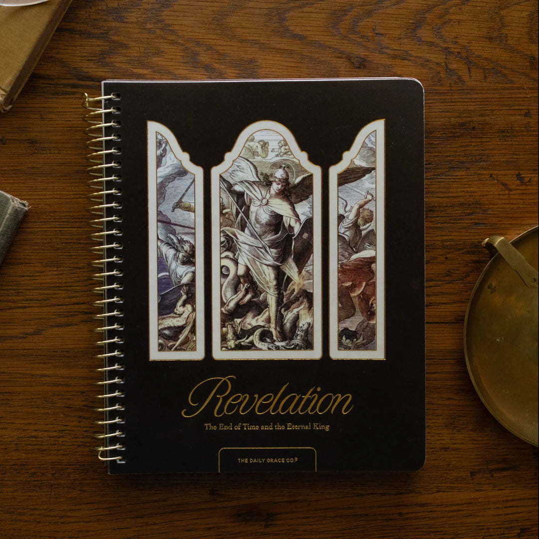 Revelation Spiral Study cover on a wooden table next to a bronze candlestick and some old books