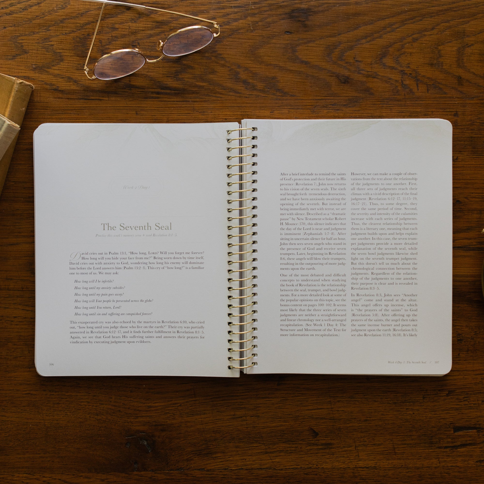 Revelation Spiral Study opened to page 106, the Seventh Seal, on a wooden table next to a pair of glasses