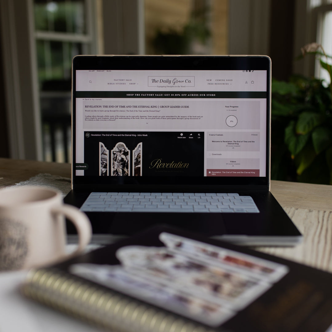 Revelation Group Leader Guide loaded on a laptop sitting on a table next to a Revelation spiral and a coffee cup