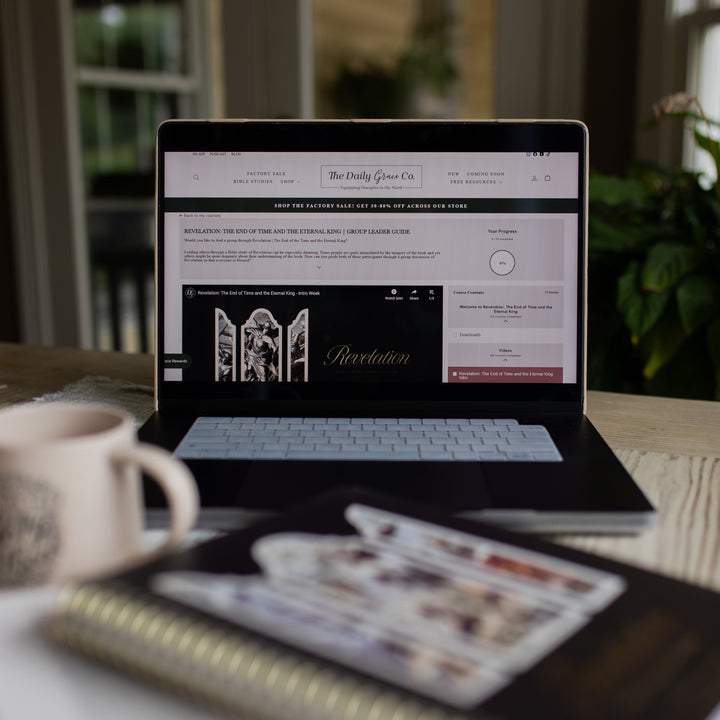 Revelation Group Leader Guide loaded on a laptop sitting on a table next to a Revelation spiral and a coffee cup