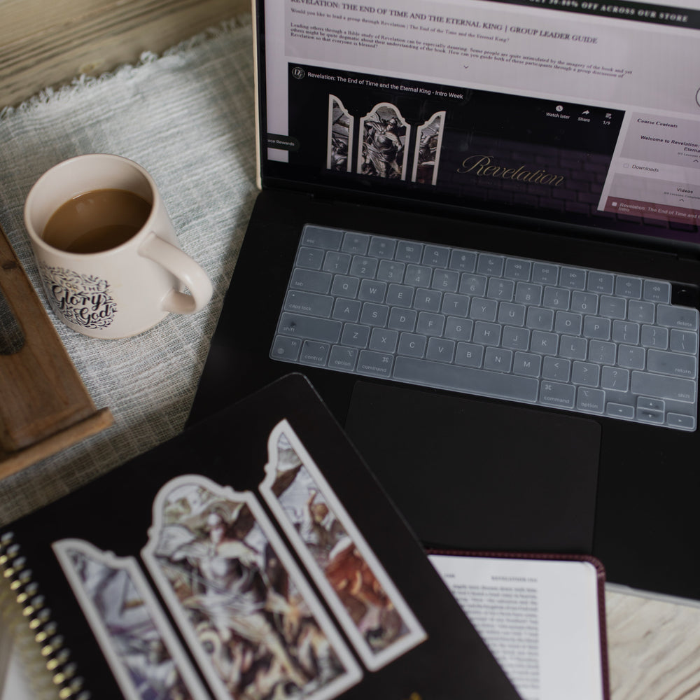 Revelation Group Leader Guide loaded on a laptop on a wooden table next to a Revelation spiral and a coffee cup