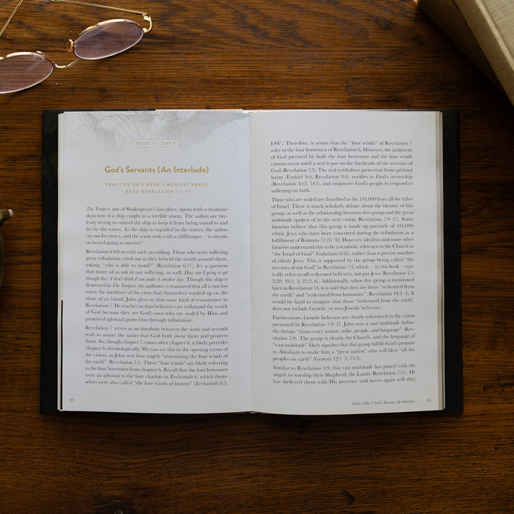 Revelation Hardcover opened to week 3 and day 5 page, God's Servants, on a wooden table next to a pair of glasses