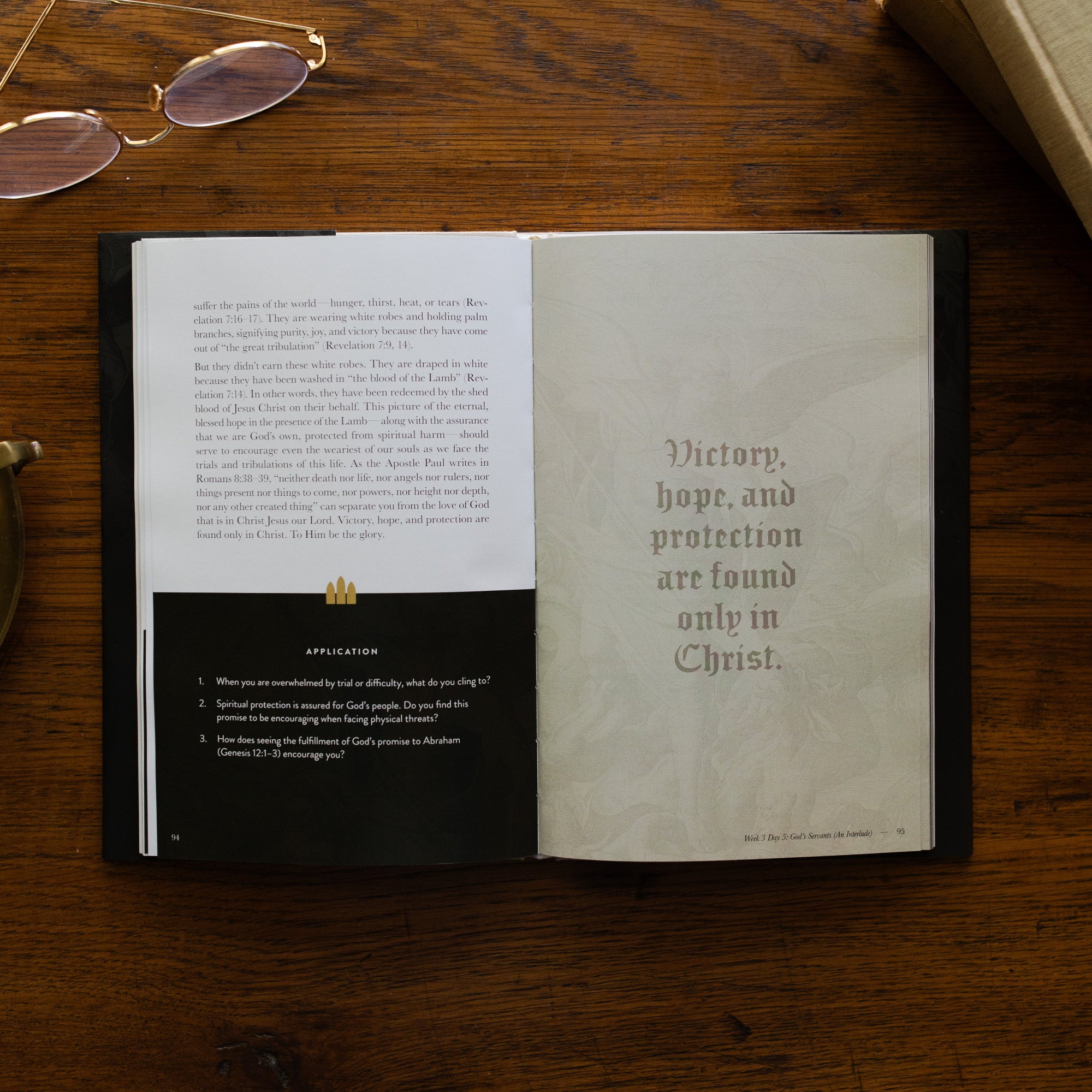 Revelation Hardcover opened to week 3 and day 5 page, Applications and devotional, on a wooden table next to a pair of glasses