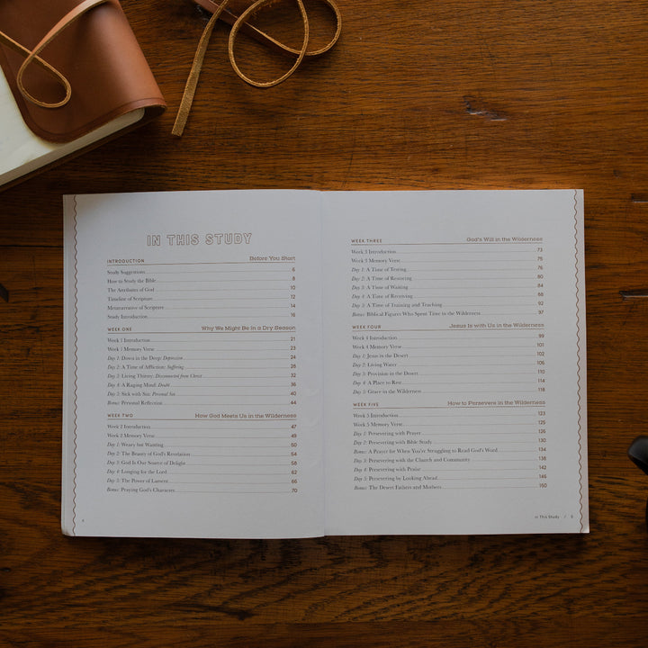 Rivers of Renewal Study open to the table of contents page; The study is resting on a wooden table next to a bible with a leather cover