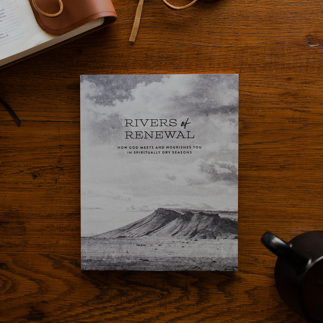 Rivers of Renewal Mens Study Cover on a brown wooden table next to a leather wrapped bible